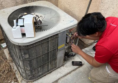 Technician repairing an outdoor air conditioning unit.
